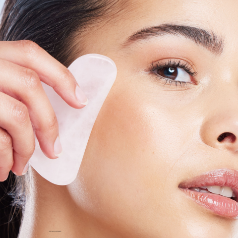 gua sha visage blanc coeur massant la joue