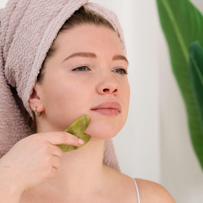 gua sha visage pierre jade sur joue coeur